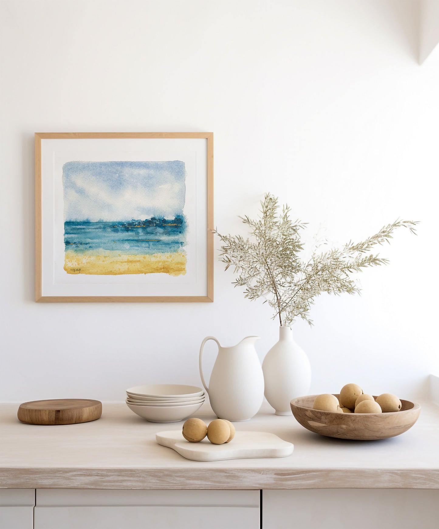 Decorative setting with a framed painting, vases, and bowls on a wooden surface.